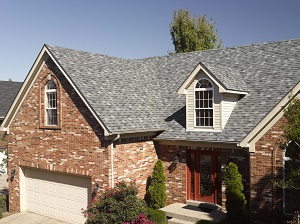 Reddish brick house with gable clad in off-white lap siding with entire home in gray architectural dimensional roofing